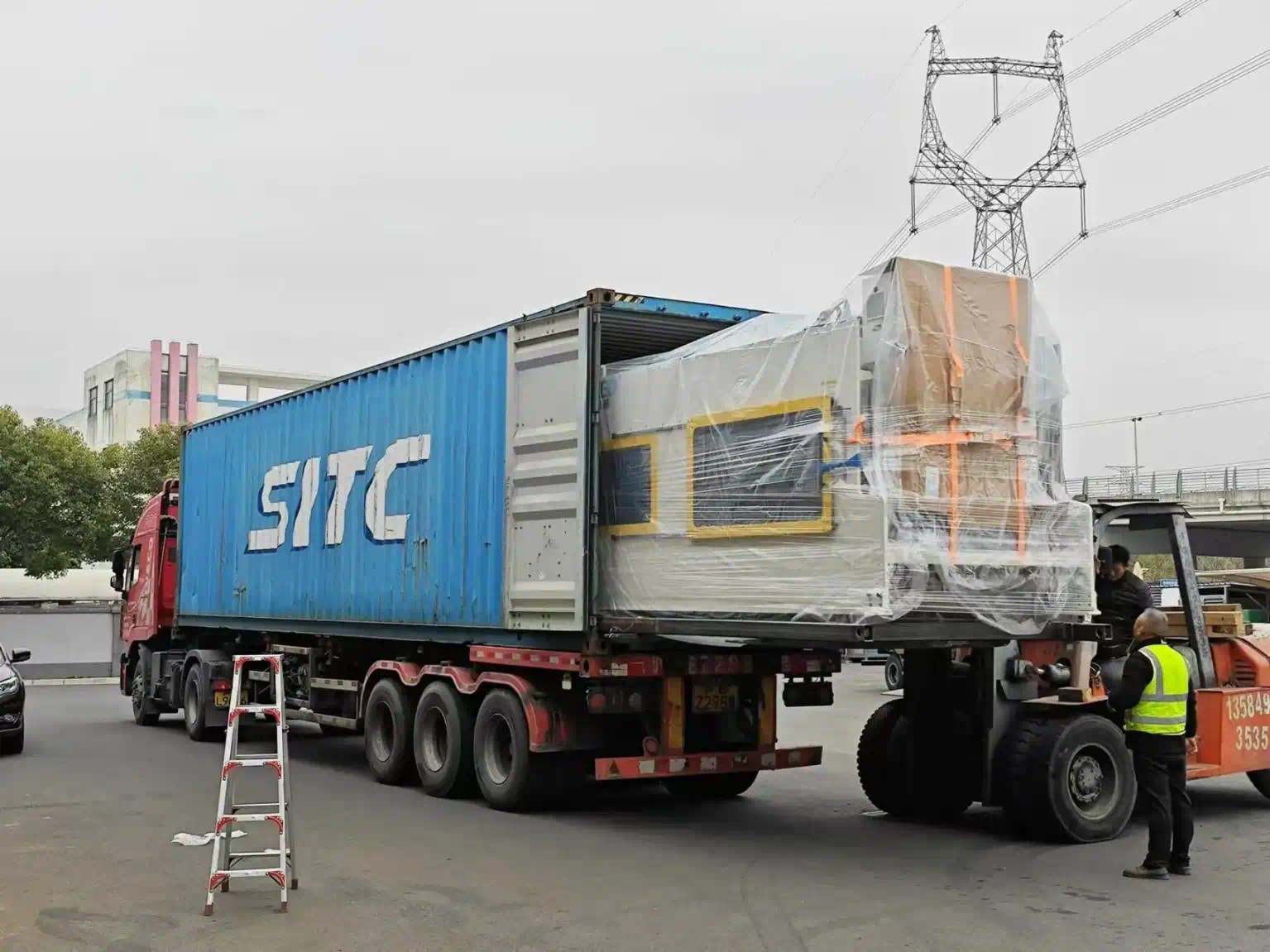 customer folder gluer being loaded into container by forklift